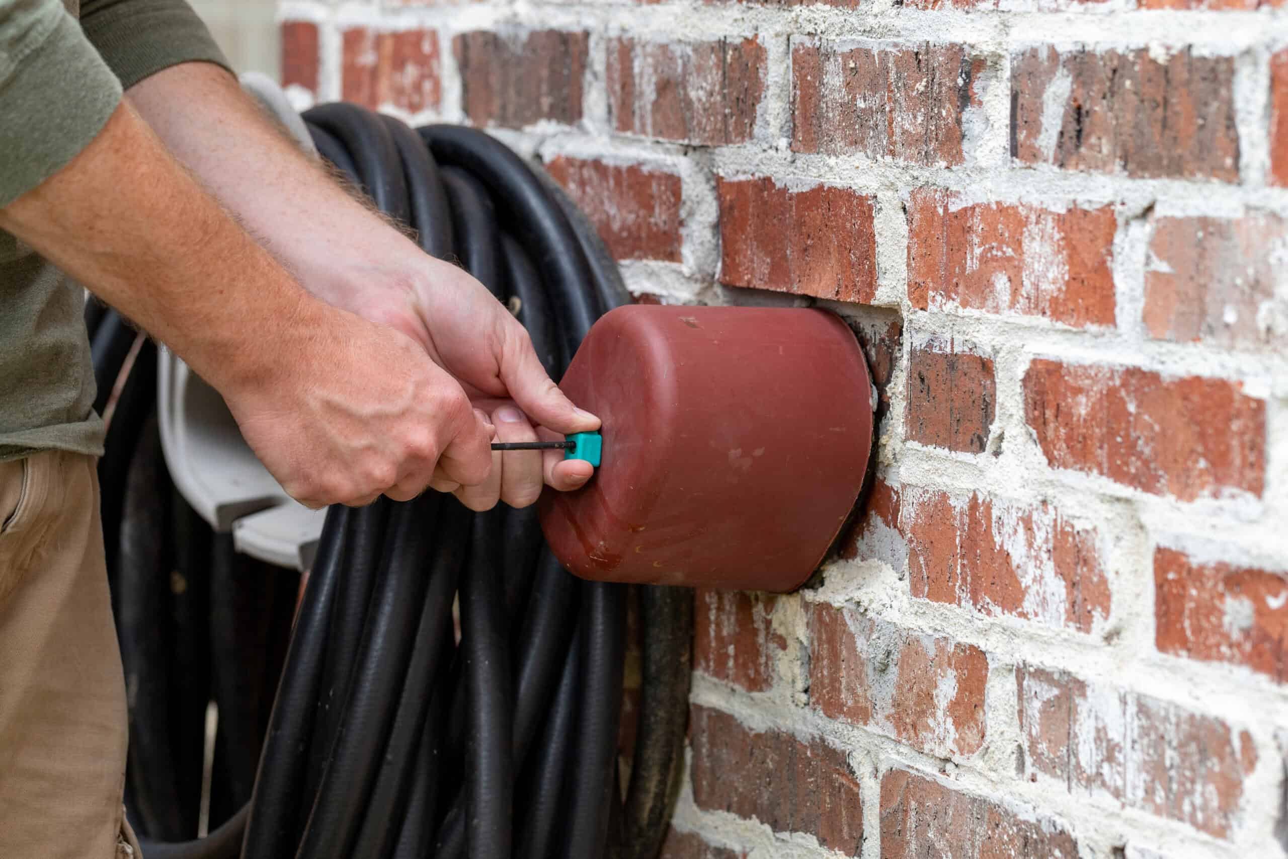 man sealing an outdoor hose with a cover