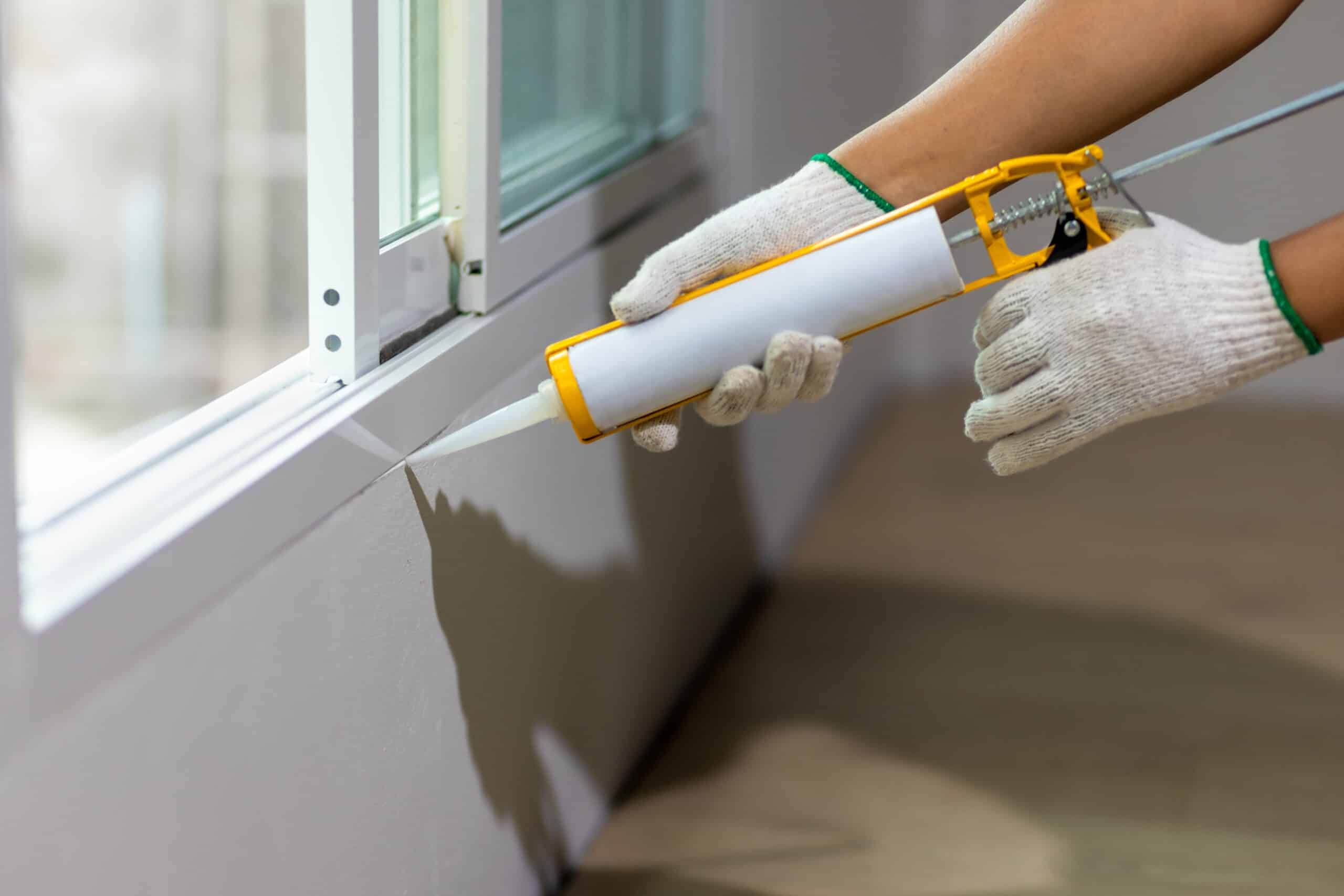 window being sealed with caulk for cold and warm weather