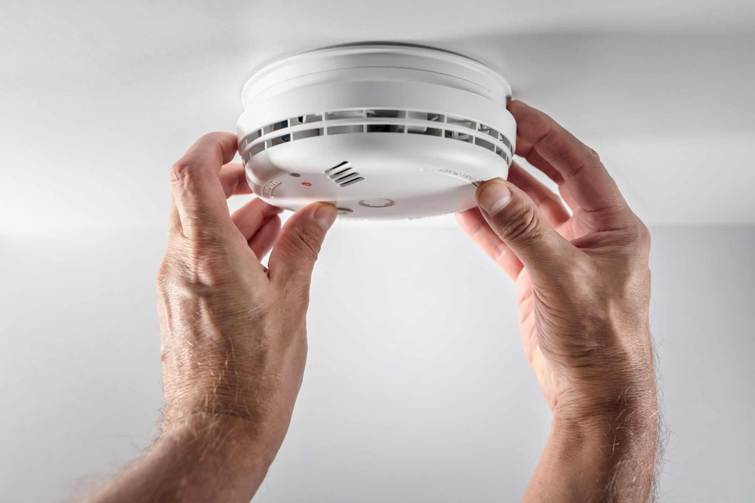 man testing smoke detector