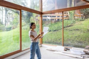 woman planning a house design in front of wooden beams